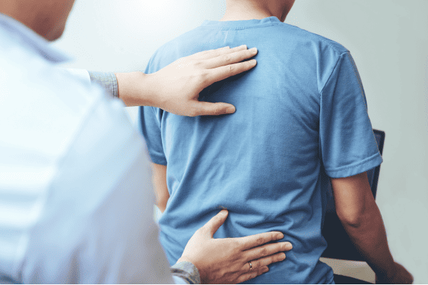 Medical physician working with patient to diagnose sciatic nerve pain